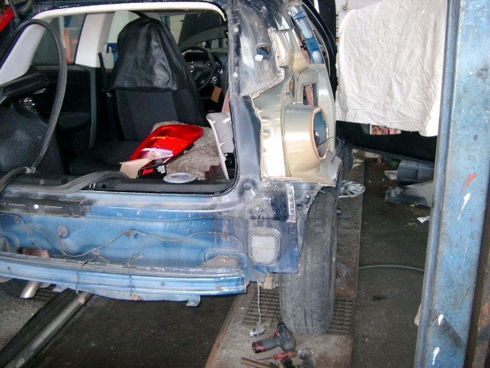 Autokarosserie auf einer Hebebühne in der Werkstatt von Autohaus Raithel.