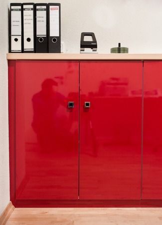 Ein roter Schrank mit Ordnern darauf