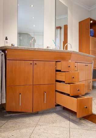 Ein Badezimmerschrank mit offenen Schubladen und einem Waschbecken