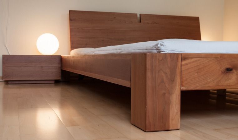 Ein Schlafzimmer mit einem Holzbett und einem Nachttisch