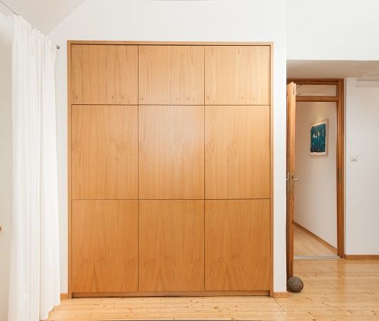 Ein Holzschrank in einem Raum mit einem Bild an der Wand