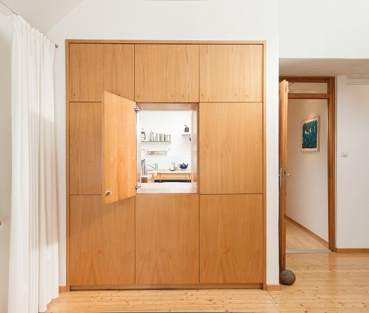 Ein Holzschrank in einem Raum mit offener Tür
