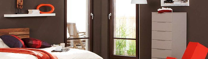 Ein Schlafzimmer mit Bett, Kommode, Stuhl und Spiegel.