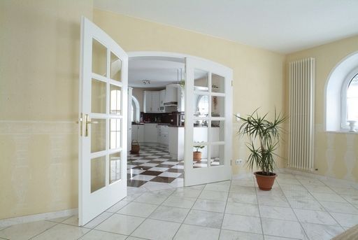 Ein leerer Raum mit einer Topfpflanze und Fenstertüren