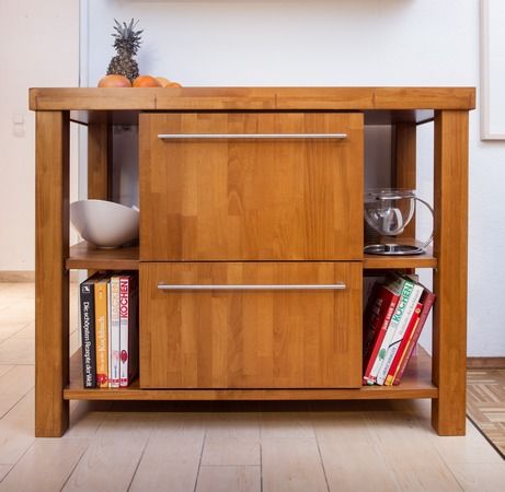 Ein Holzschrank mit Schubladen und einem Regal mit Büchern darauf