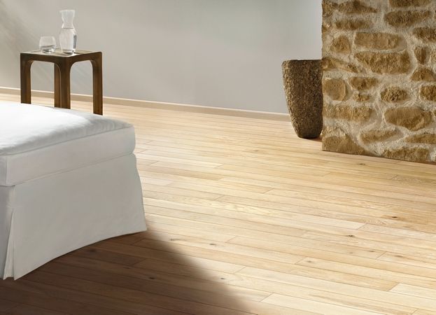 Ein Wohnzimmer mit Holzboden und Steinwand.