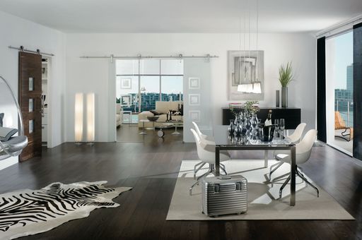 Ein Wohnzimmer mit Tisch und Stühlen und einer Glasschiebetür