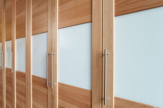 Eine Reihe Holzschränke mit weißen Glastüren.