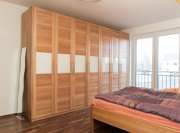 Ein Schlafzimmer mit großem Holzschrank und Bett