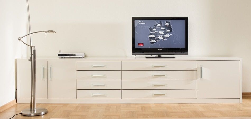Auf einem weißen Entertainment-Center steht ein Flachbildfernseher.