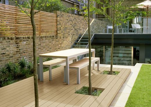 Eine Holzterrasse mit Tisch und Bänken darauf