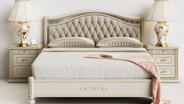 Un dormitorio con una cama, mesitas de noche, lámparas y un libro sobre la cama.