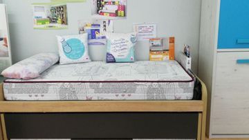 Una cama con un colchón y almohadas encima en una habitación.