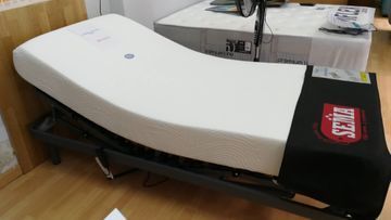 Un colchón blanco está sobre un piso de madera en una habitación.