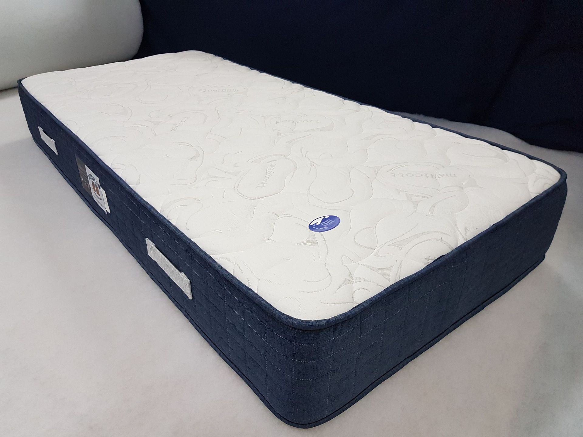 Un colchón azul y blanco con una flor encima.