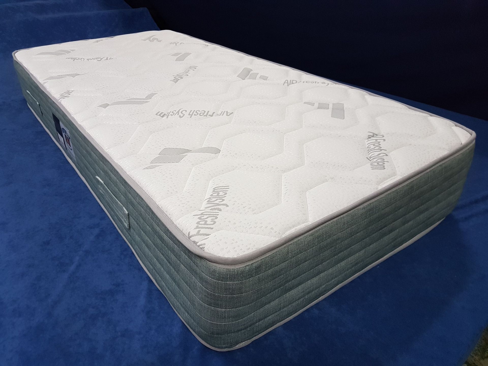 Un colchón blanco está sobre un sofá azul.