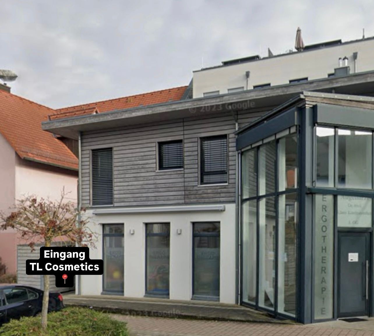 Ein Gebäude mit einem Schild mit der Aufschrift „Eingang TL Cosmetics“