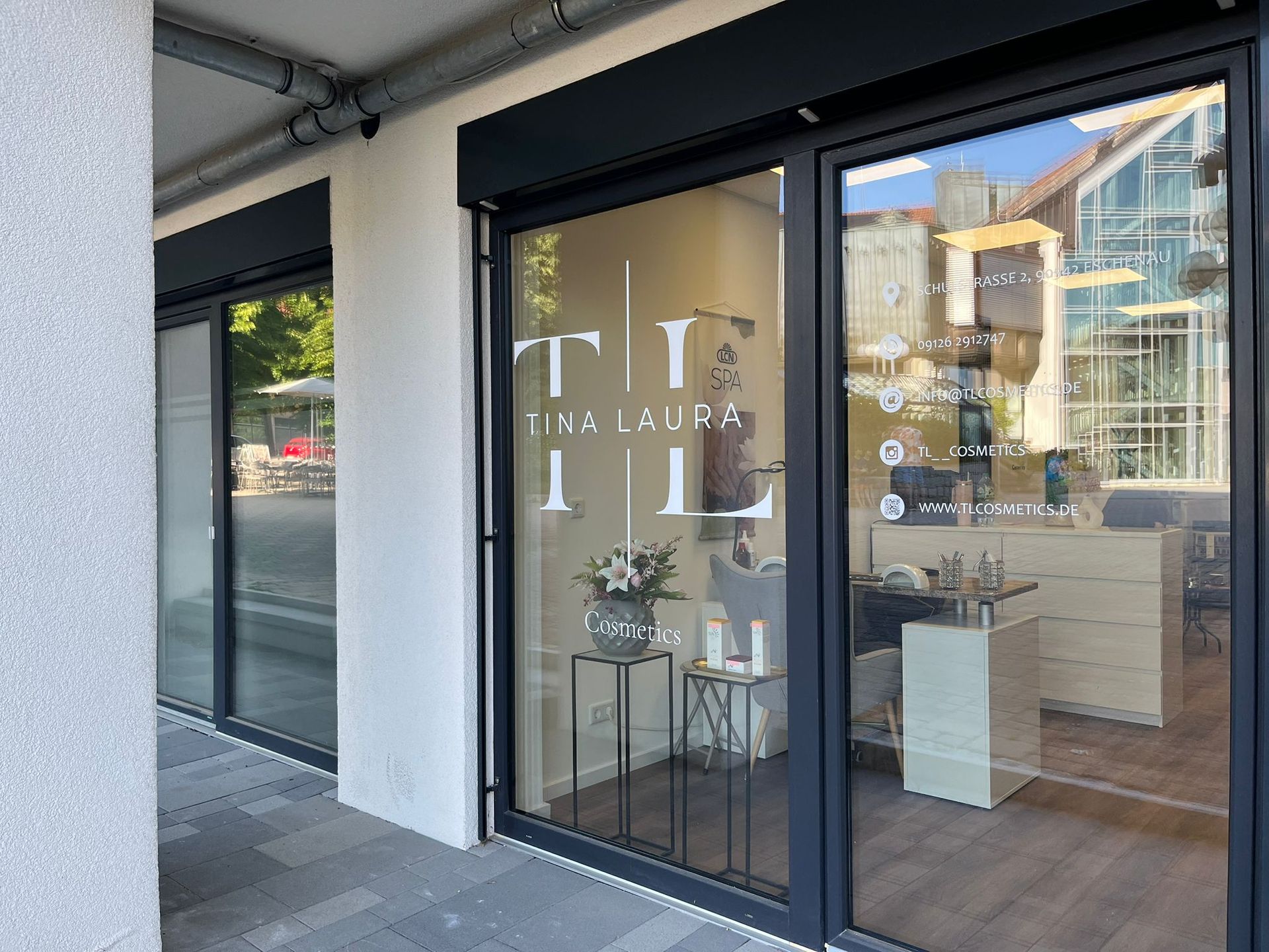 Eine Ladenfront mit einer großen Glastür und einem Schild mit der Aufschrift „tl“.