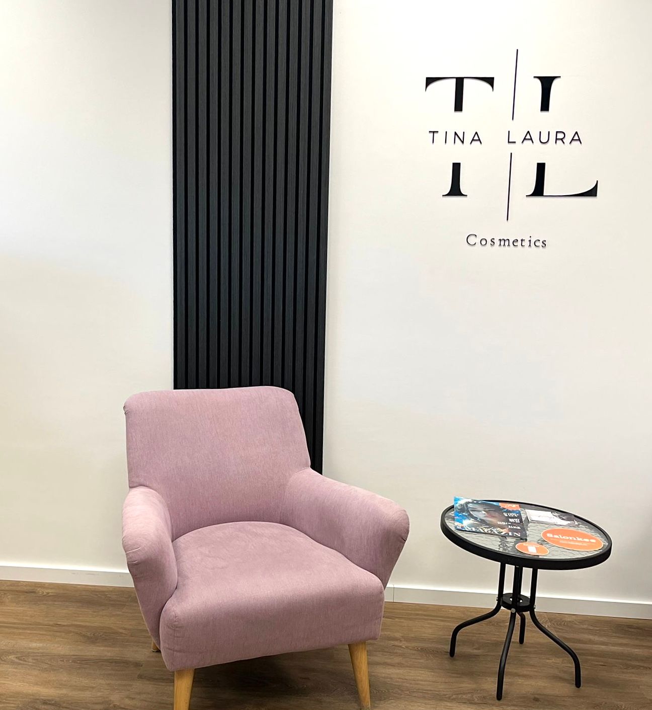 In einem Zimmer steht ein rosa Stuhl neben einem kleinen Tisch.