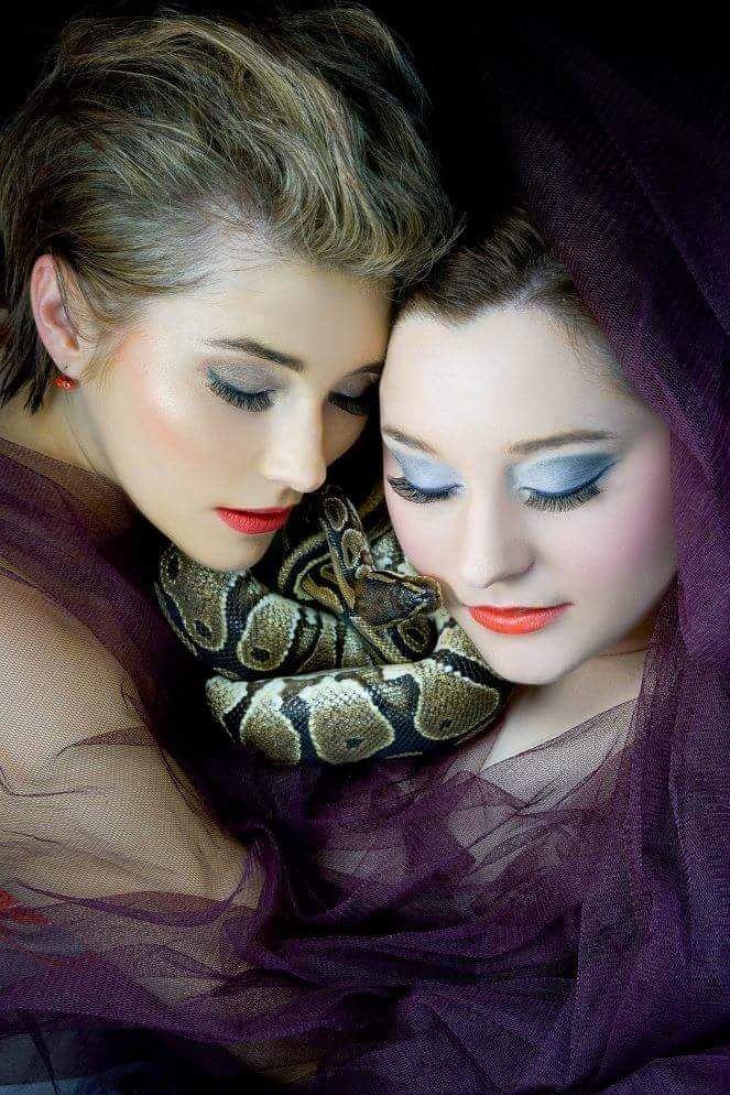 Eine Frau in rotem Hemd führt eine Gesichtsbehandlung an einer in ein weißes Handtuch gehüllten Kundin durch.