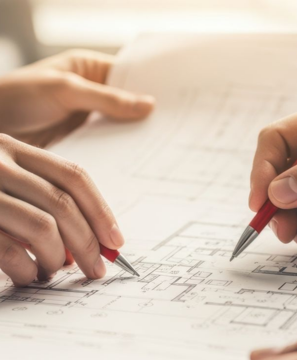 Main tenant un stylo pointant vers un plan.