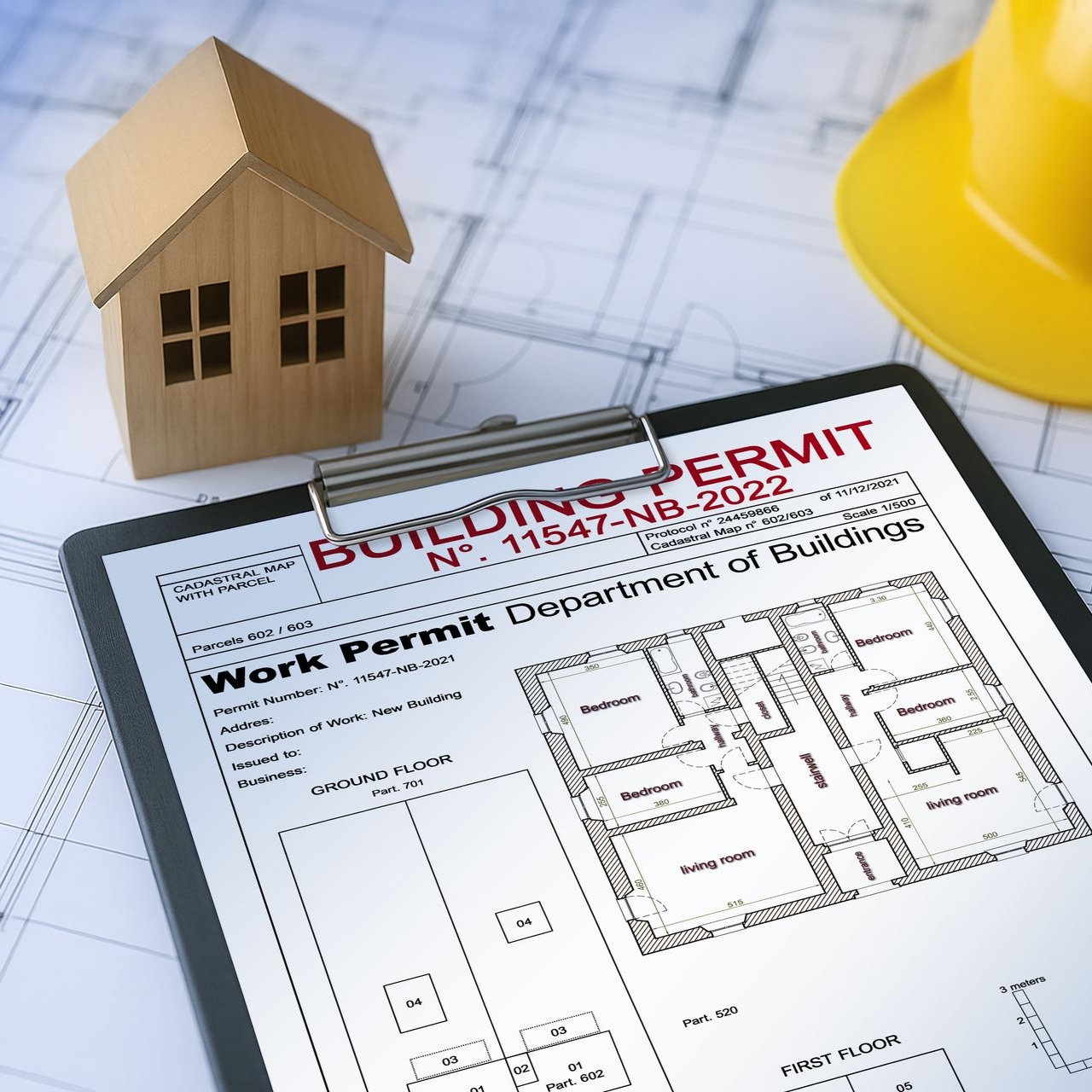 Permis de construire avec une petite maquette de maison et un casque de chantier sur un plan.