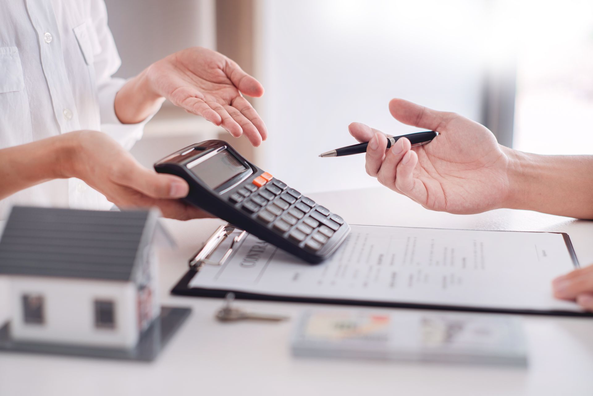 Une main qui tient une calculatrice et des documents.