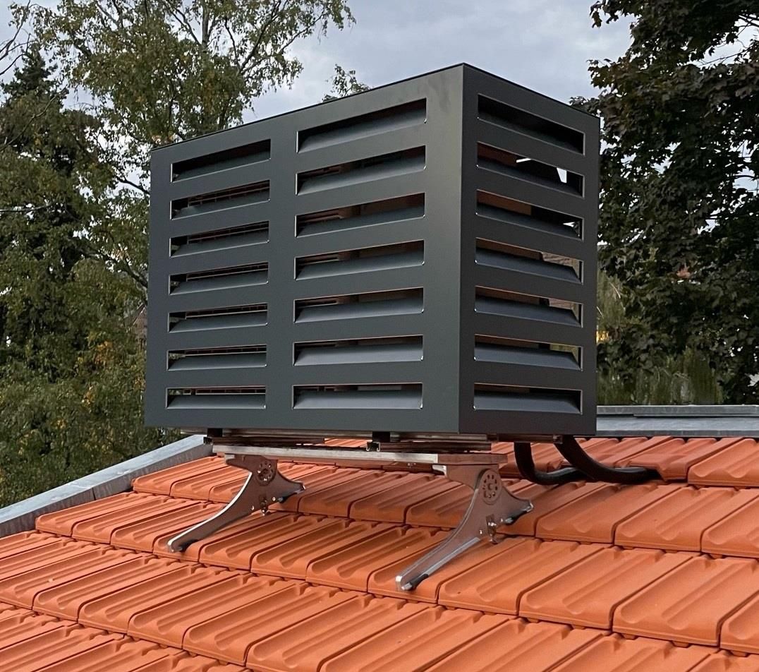 Eine schwarze Box sitzt auf einem roten Ziegeldach