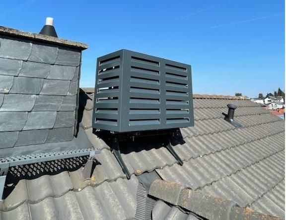 Eine schwarze Box sitzt auf einem Ziegeldach