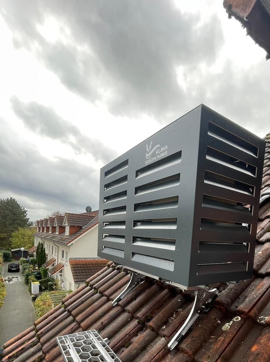 Auf einem Ziegeldach sitzt eine schwarze Box.