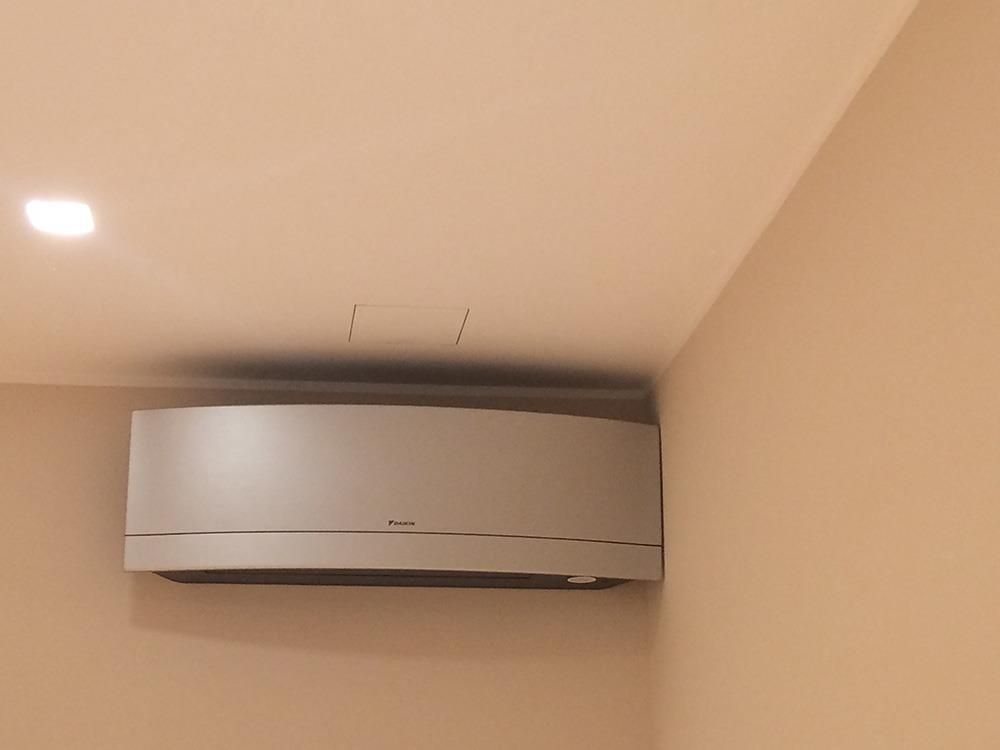 Eine weiße Klimaanlage ist in einem Raum an der Wand montiert