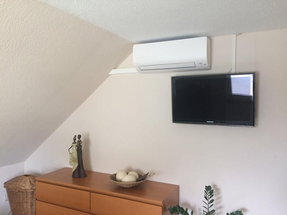 Ein Wohnzimmer mit einer Kommode und einem Flachbildfernseher