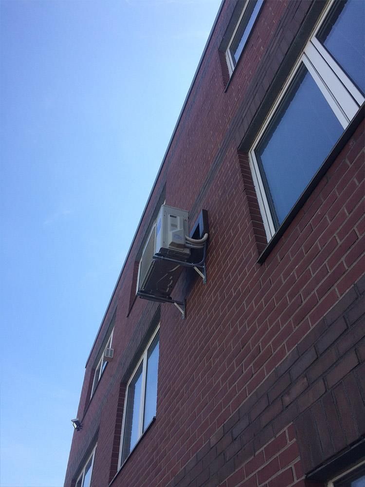 Blick nach oben auf ein Backsteingebäude mit blauem Himmel im Hintergrund