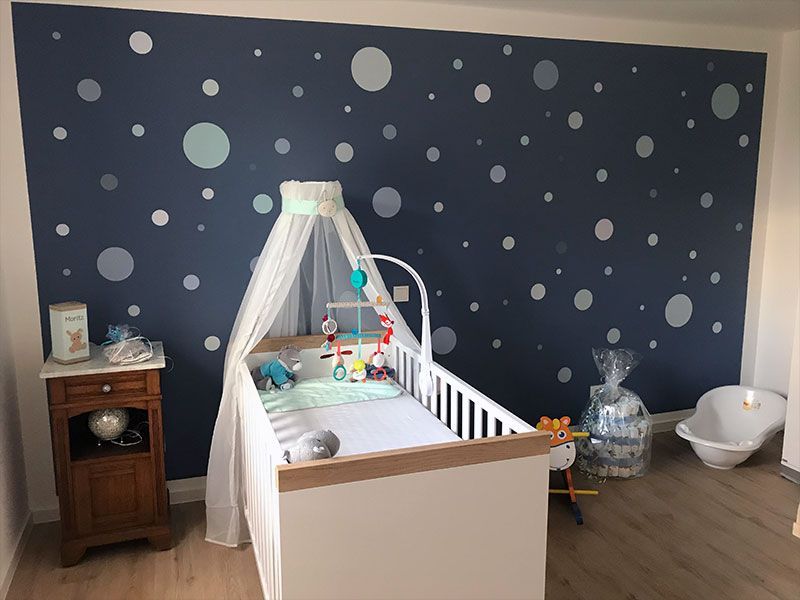 Ein Babyzimmer mit Kinderbett, Nachttisch und Badewanne.