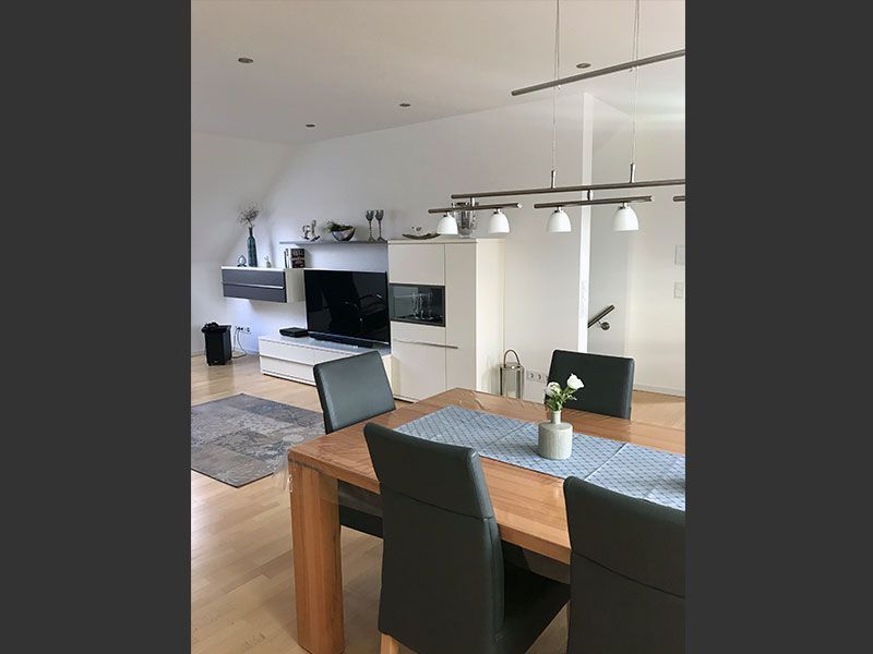 Ein Wohnzimmer mit Tisch und Stühlen und einem Fernseher.
