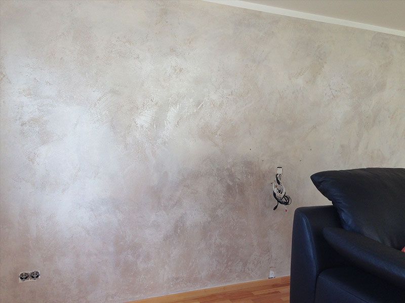 Ein Wohnzimmer mit einer Couch und einer Wand mit einer Lampe daran.