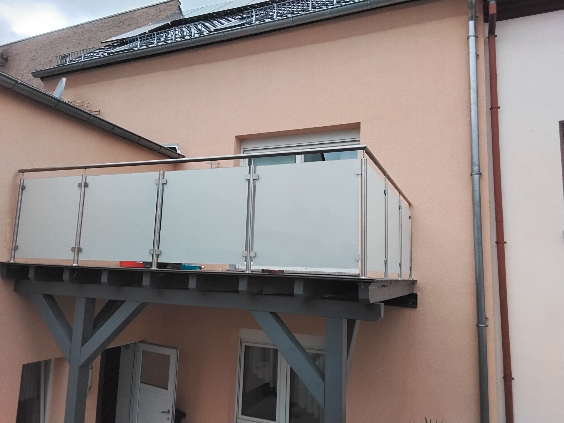 Kleiner Vorstellbalkon mit Milchglasfüllung und seitlichen Edelstahlpfosten
