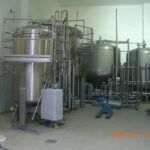 Rohrleitungssystem mit Tanks und Armaturen in Produktionshalle