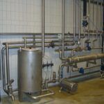 Industrialle Anlage mit Rohrleitungen, Ventilen und Edelstahlbehälter
