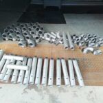 Metallteile und Gewindeelemente übersichtlich auf Werkbank angeordnet