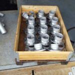 Kiste mit gefertigten Metallbauteilen in Serienproduktion