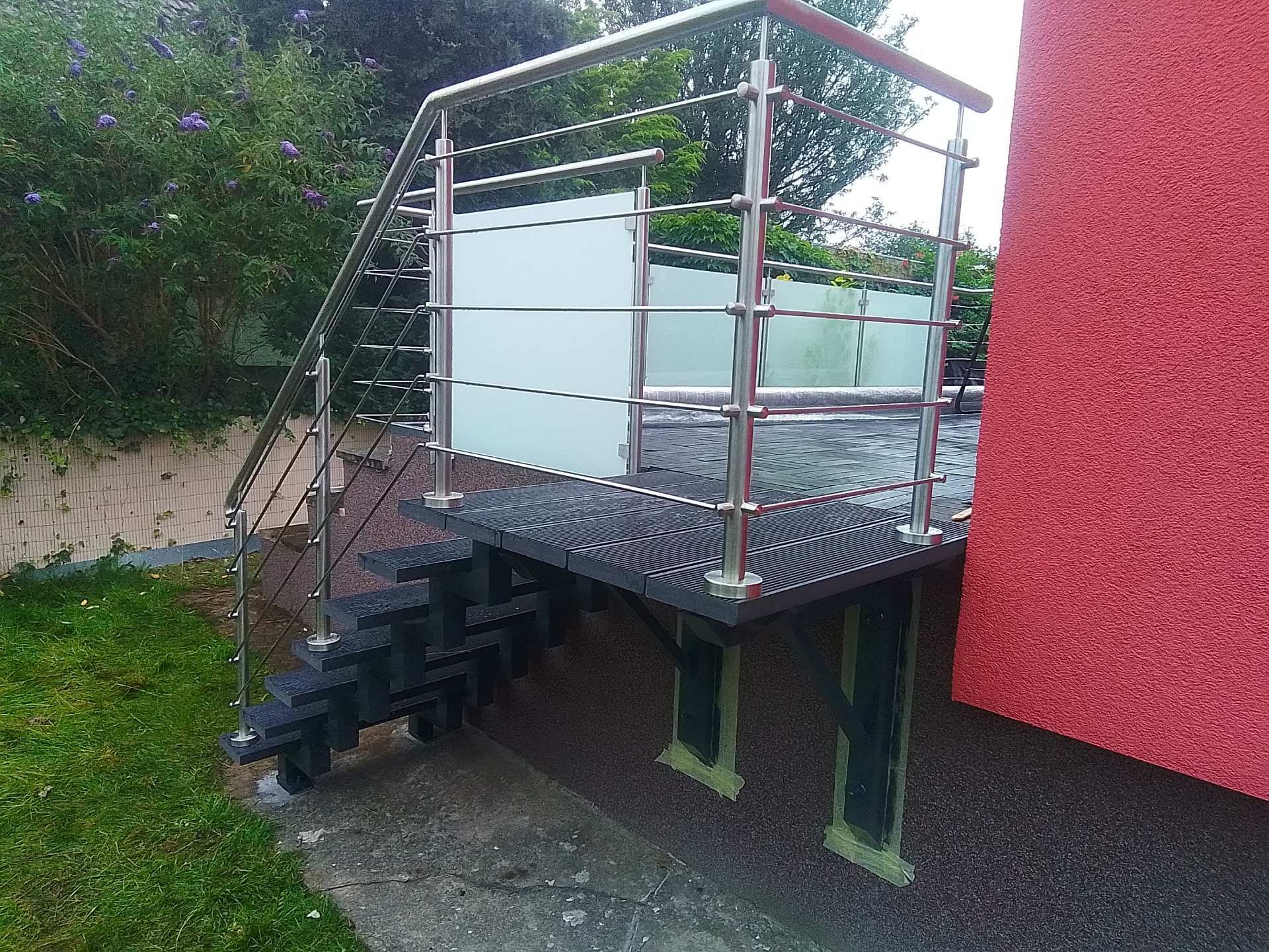 Außentreppe mit Edelstahlgeländer und Gitterroststufen an einer erhöhten Terrasse
