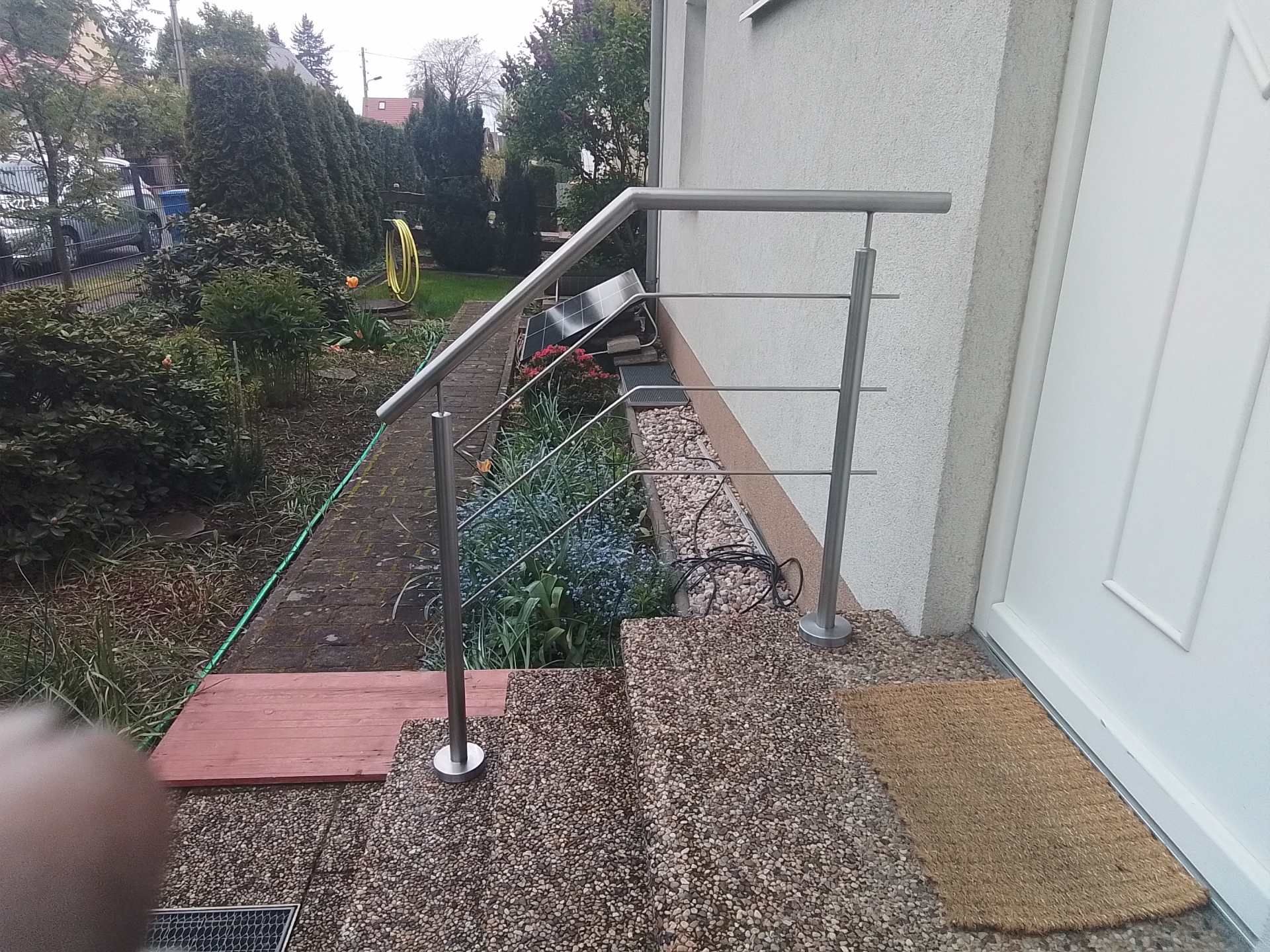 Edelstahl-Handlauf entlang eines Gartenwegs mit leichtem Gefälle