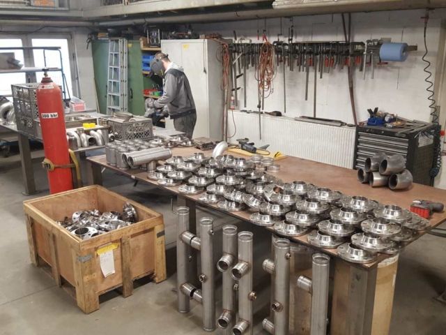 Arbeitstisch mit gefertigten Metallteilen und Werkzeugen in Metallbau-Werkstatt