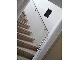 Schmale Treppe mit Holzstufen und Edelstahlhandlauf