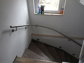 Runde Innentreppe mit Edelstahlhandlauf entlang der Wand
