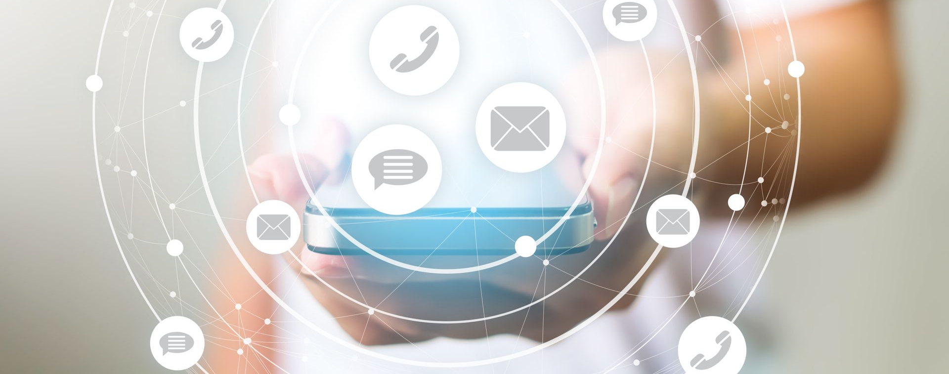 Des mains tenant un smartphone entouré d'icônes de communication, notamment des téléphones, des e-mails et des messages.