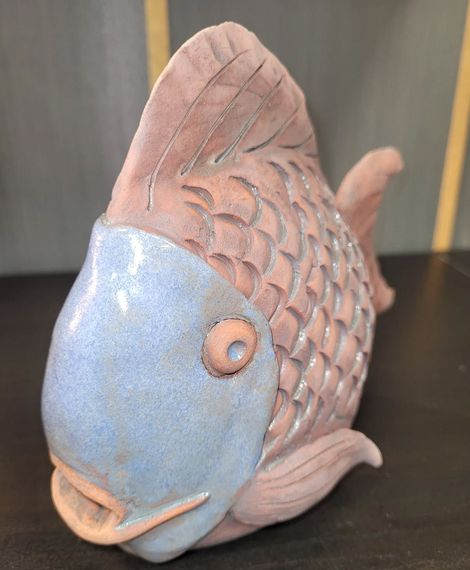 Petite figurine de poisson en céramique avec une tête bleue, des écailles roses et une bouche crème.