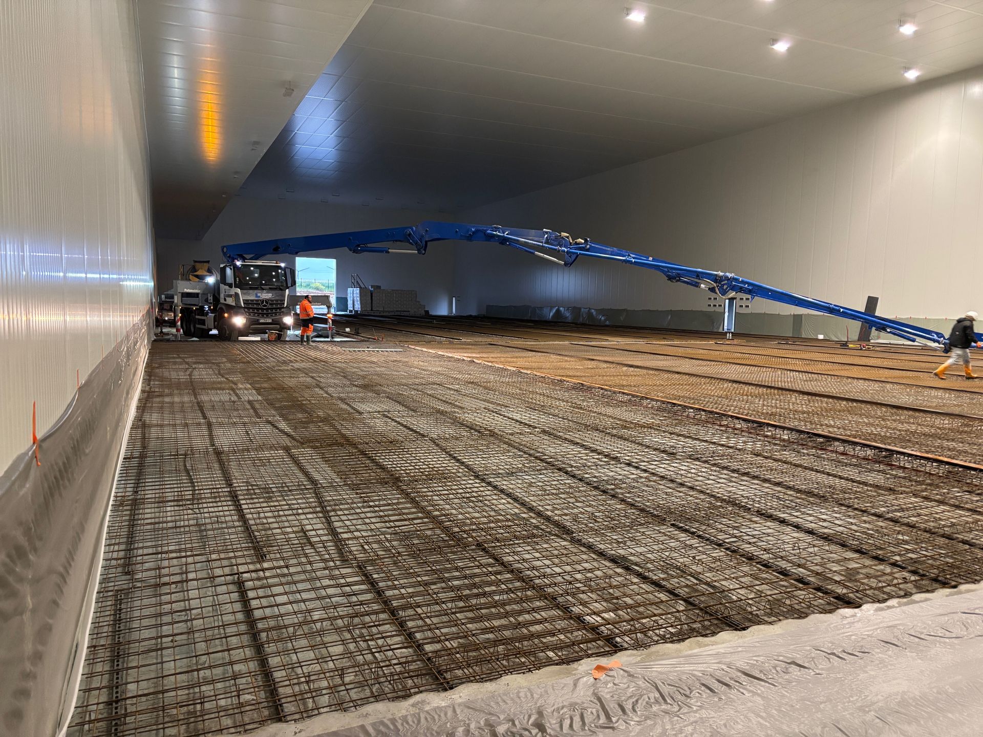 Chantier d'un bâtiment industriel avec un sol en armature en métal.