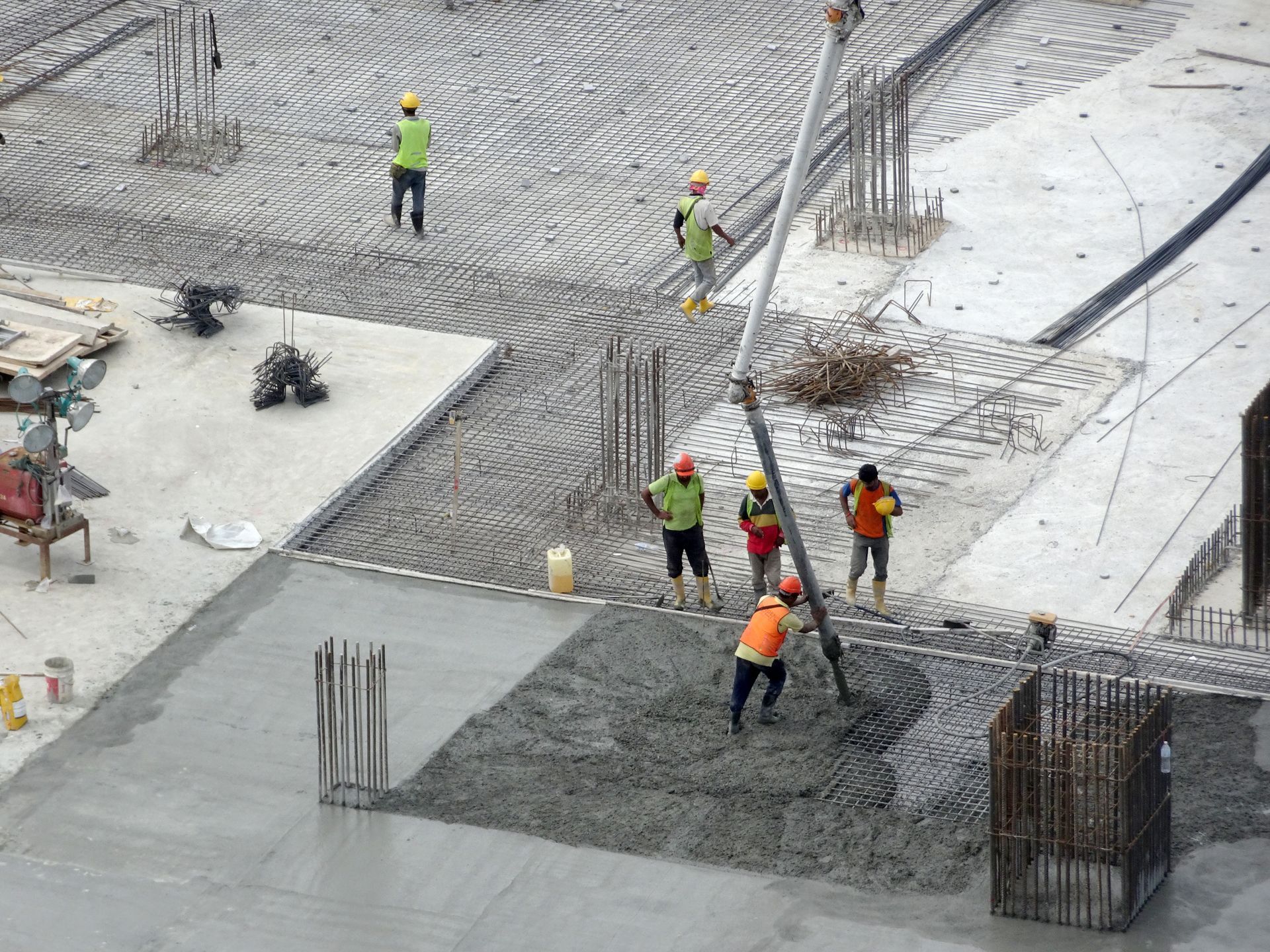 Groupe d'ouvriers sur un chantier qui coulent une dalle de béton.